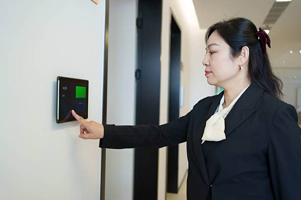 Employee clocking in with a contactless time clock to reduce manual errors