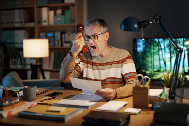Frustrated man on the phone at his desk