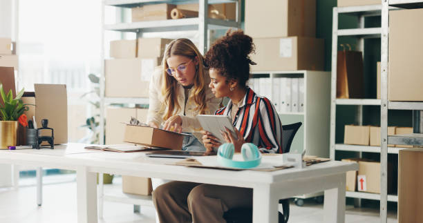 Two women reviewing records on a tablet in an office