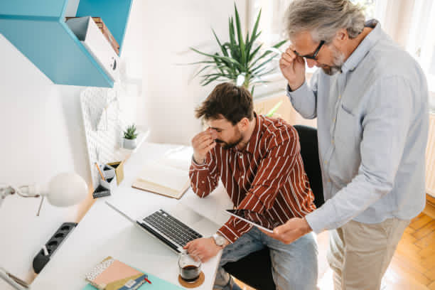 People looking at a laptop reviewing overtime exceptions