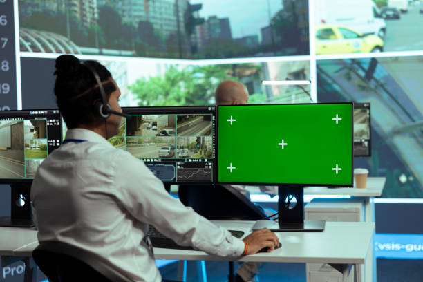 Security personnel looking at monitors with green screen elements