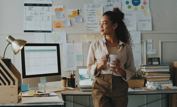 A woman standing in an office looking at a computer screen