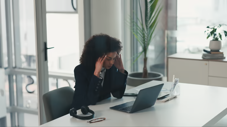 Frustrated woman at a desk with a laptop