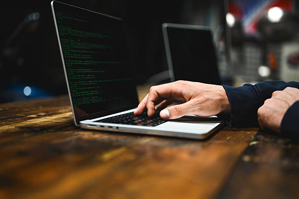 Hands typing on a laptop analyzing data