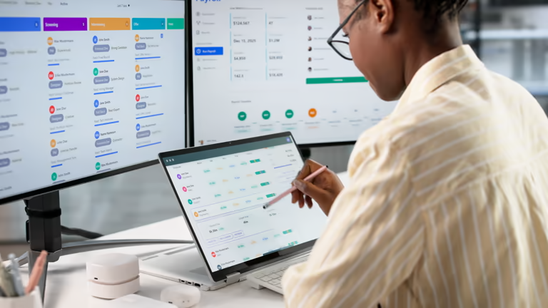 Employee using a time tracking application on dual monitors