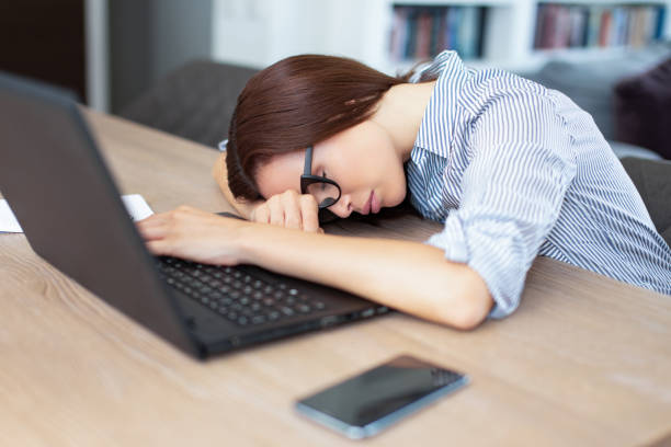 Tired employee resting head on laptop