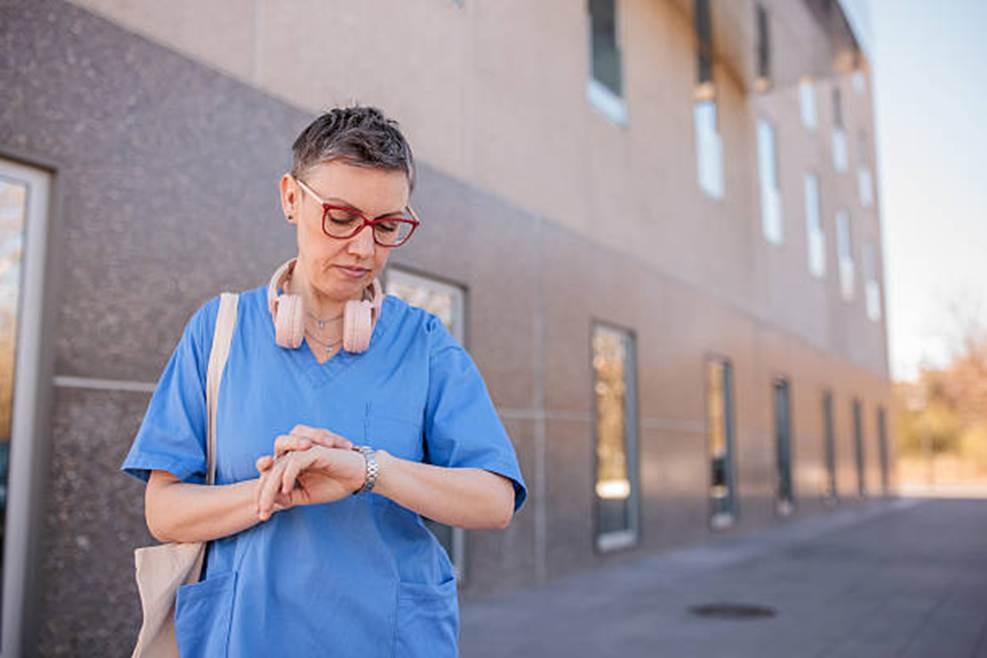 Healthcare worker checking time representing Time Doctor review