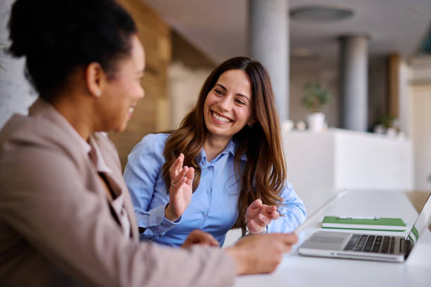 Two women discussing time tracking in an office