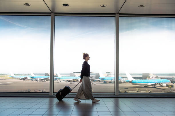 Woman walking in an airport with a suitcase