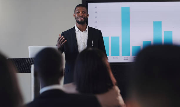 Man presenting charts to an audience