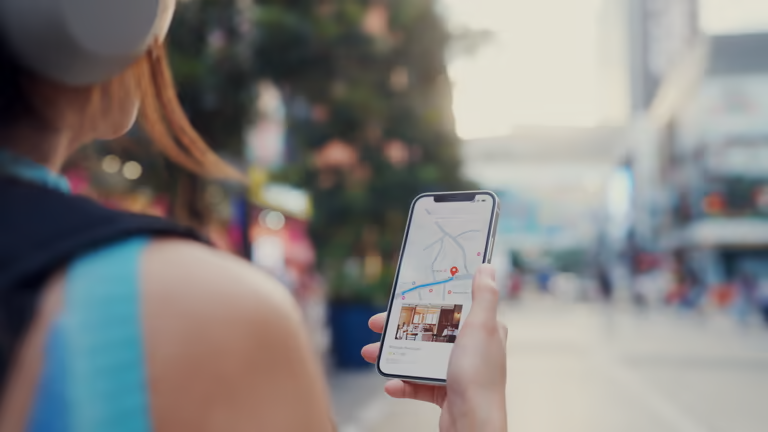 Person holding a smartphone showing a map in an office setting