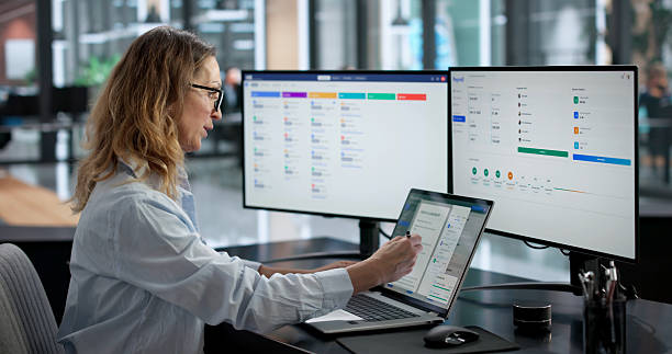 Woman working on dual monitors