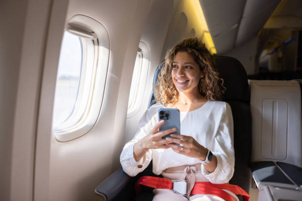 Woman using her mobile phone while sitting on an airplane