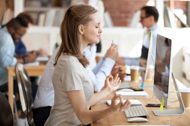 Woman taking a break and stretching at her desk