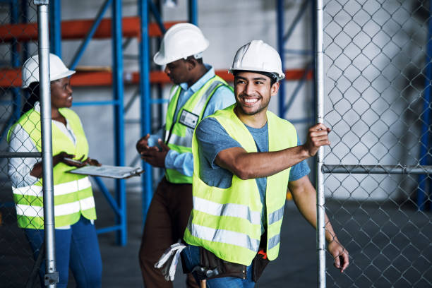 Construction workers walking near a fence
