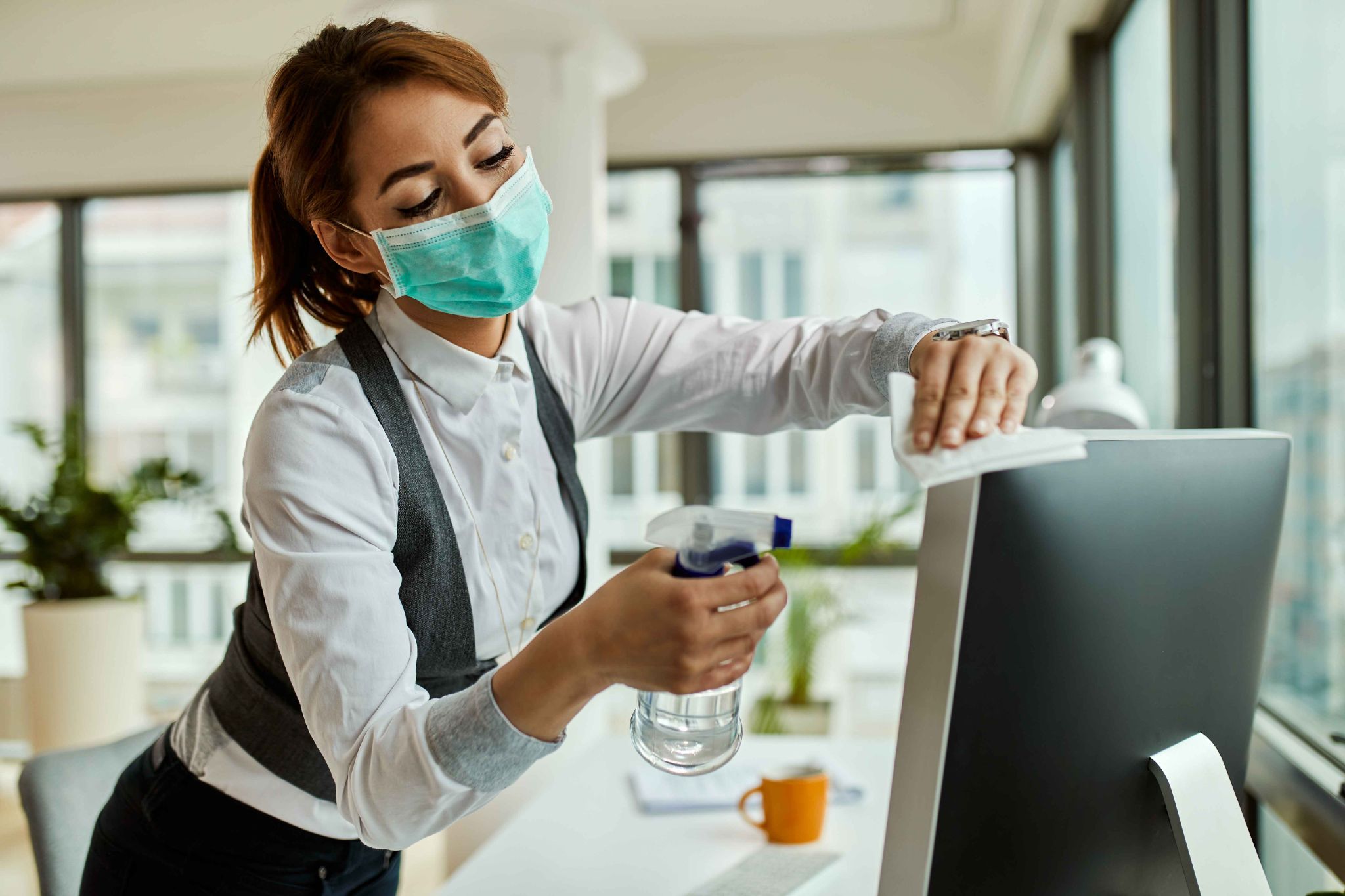Woman cleaning a computer monitor