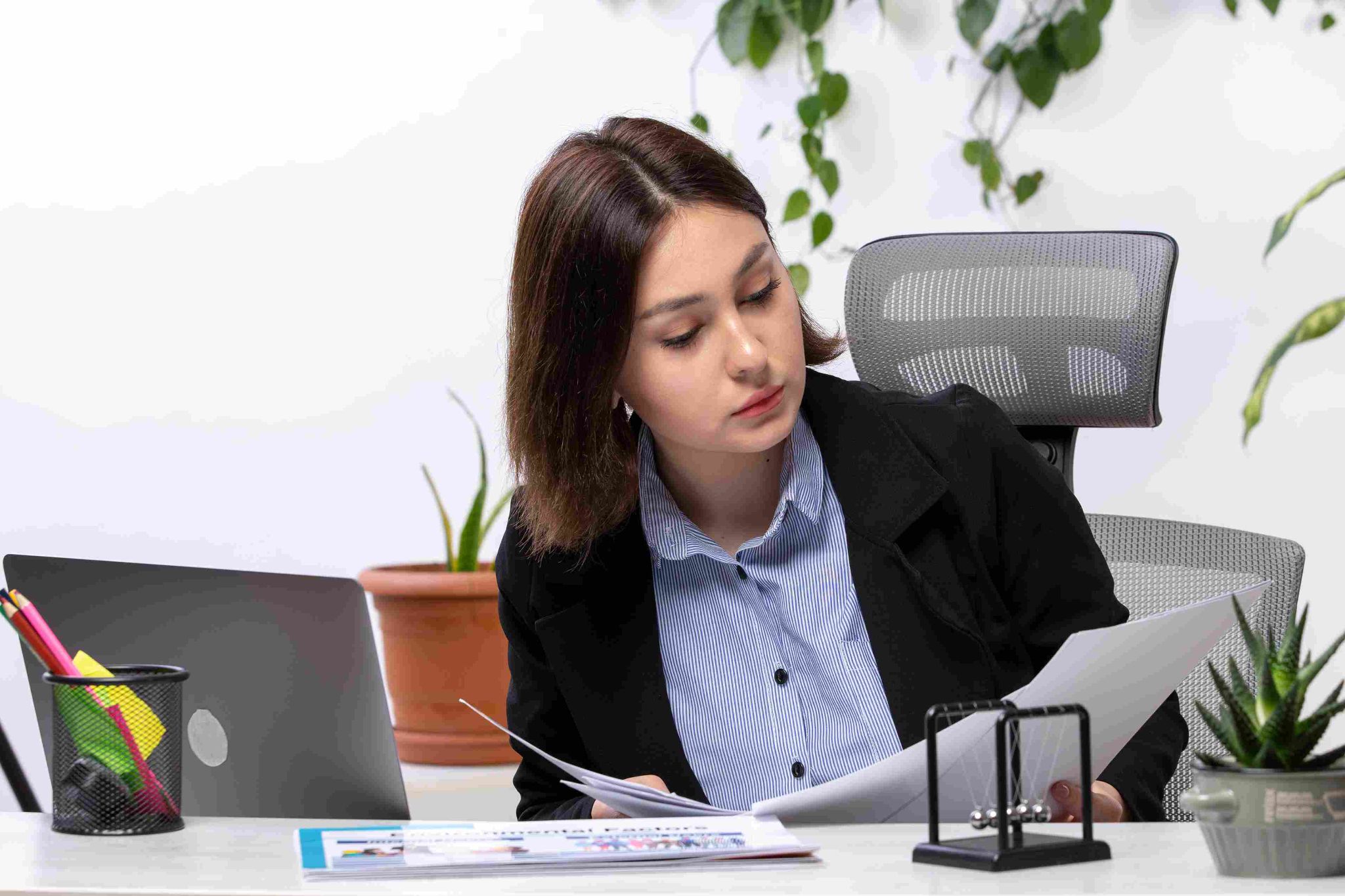 Woman at a desk looking stressed while reviewing documents