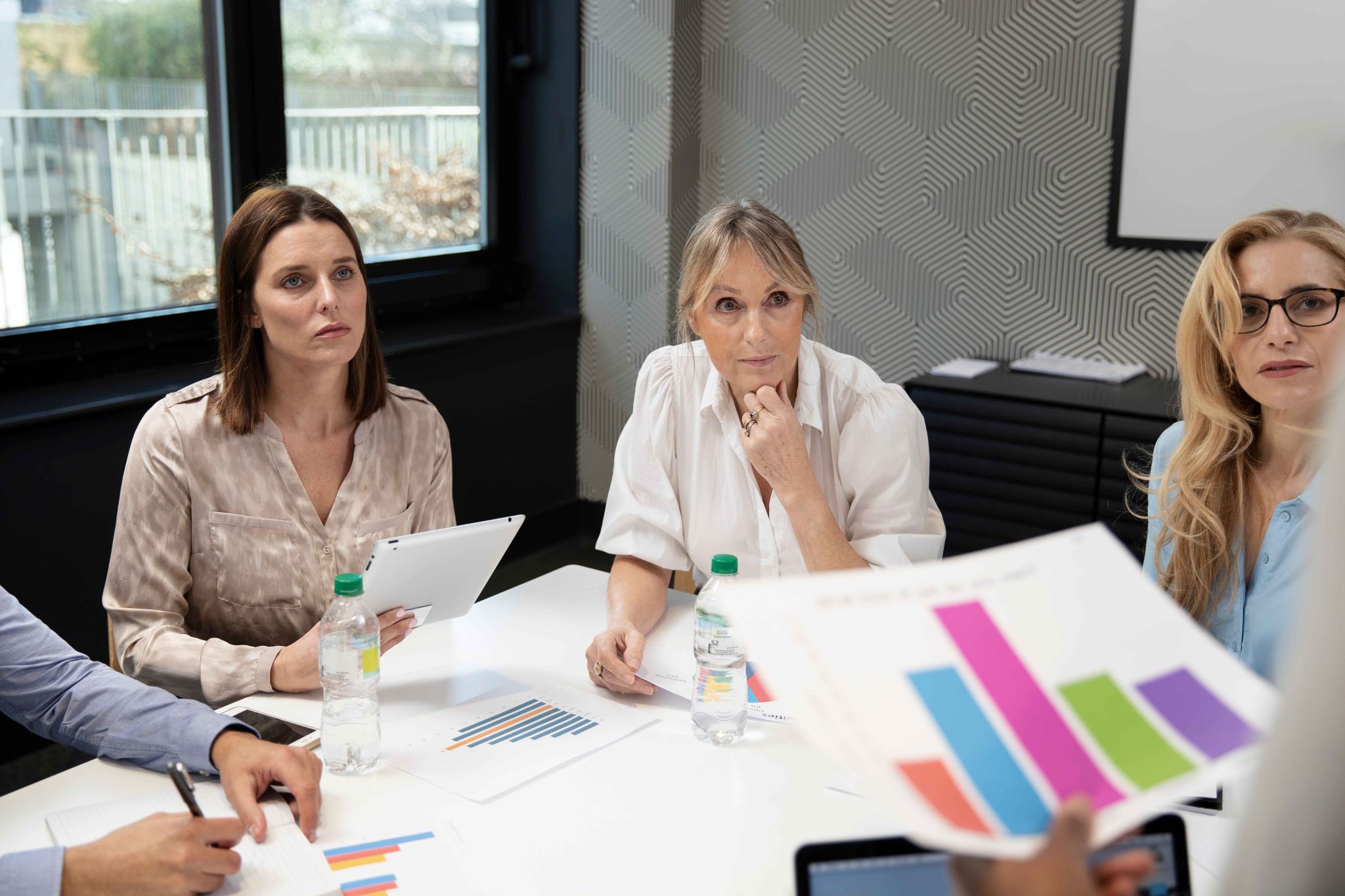 Professionals in a meeting looking at charts