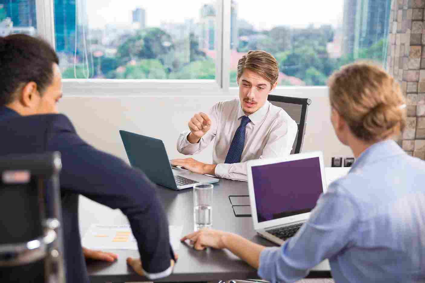 People looking at laptops in an office meeting
