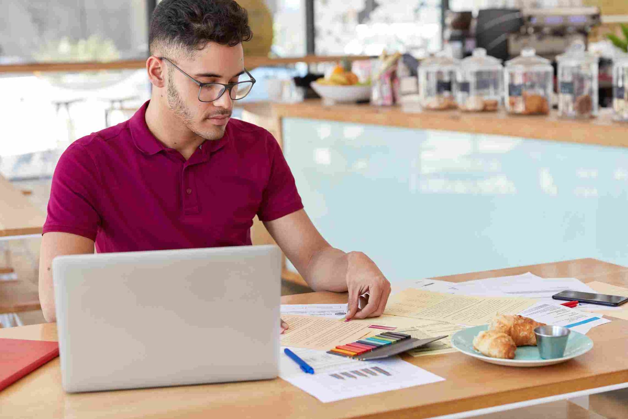 Person looking at a laptop with a pen