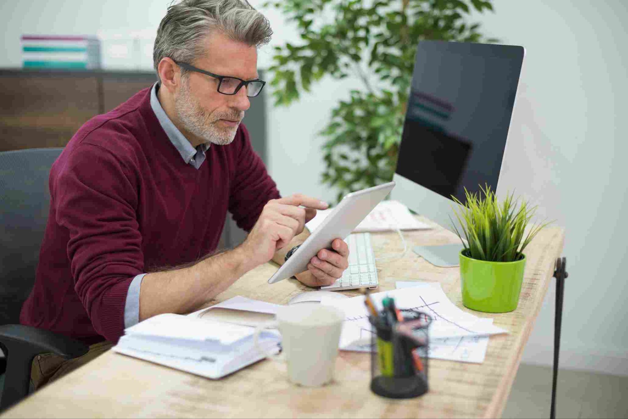Person looking at a tablet at a desk
