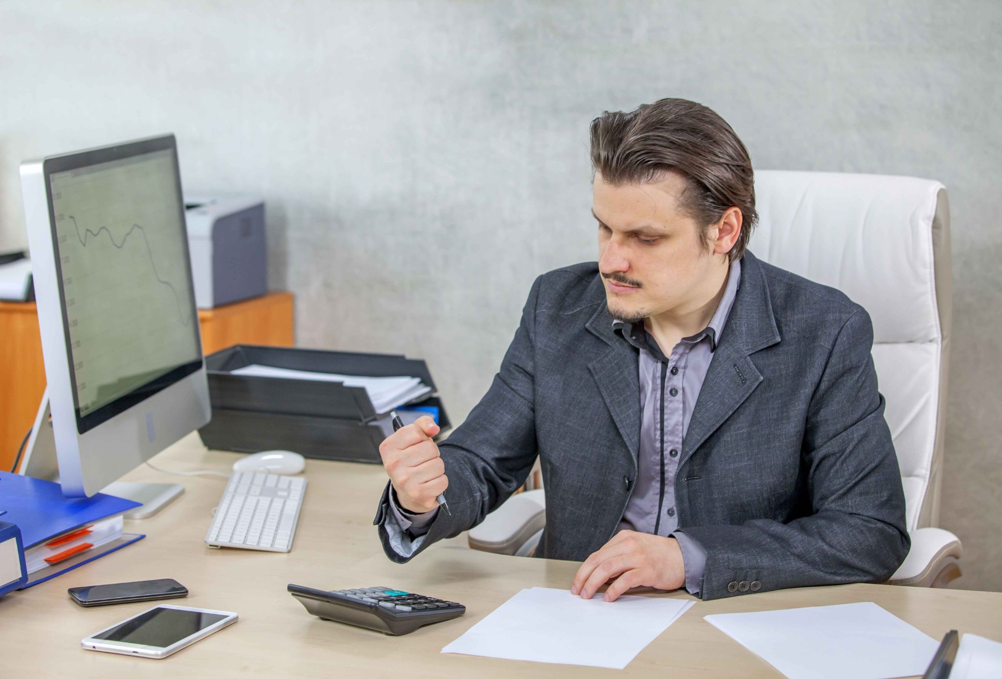 Manager reviewing payroll and overtime calculations at office desk