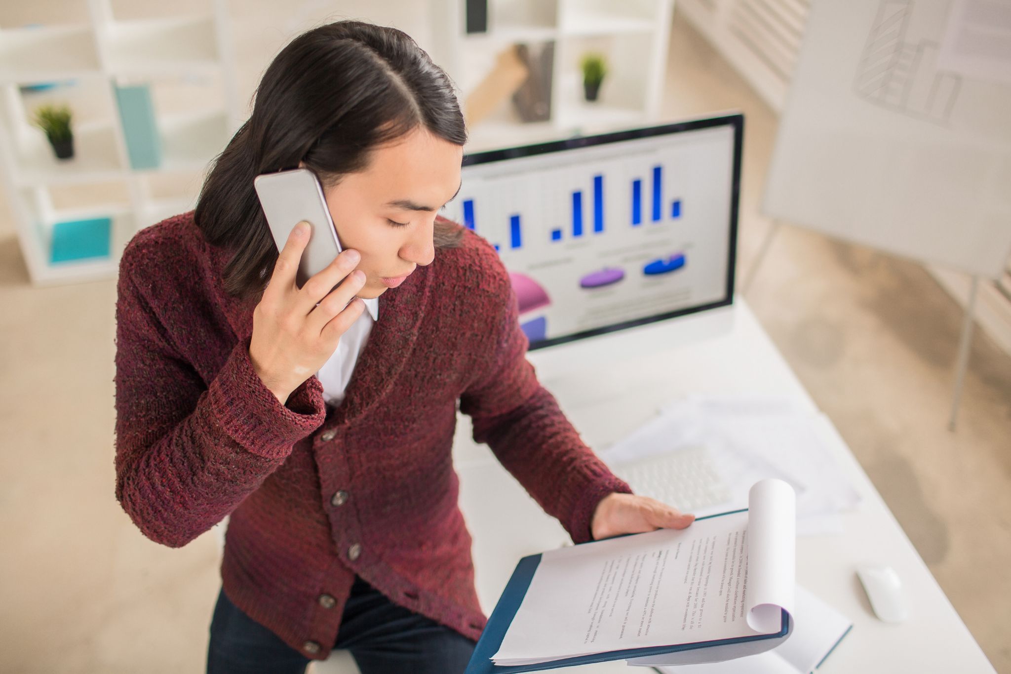 Woman analyzing overtime data on phone and laptop