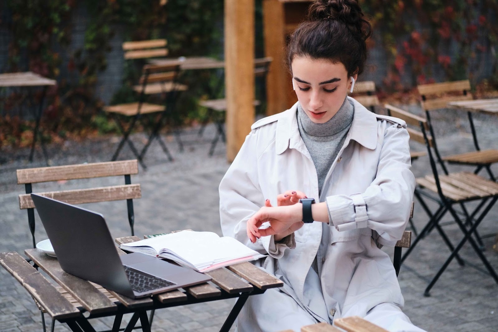 Woman tracking time on smartwatch and laptop