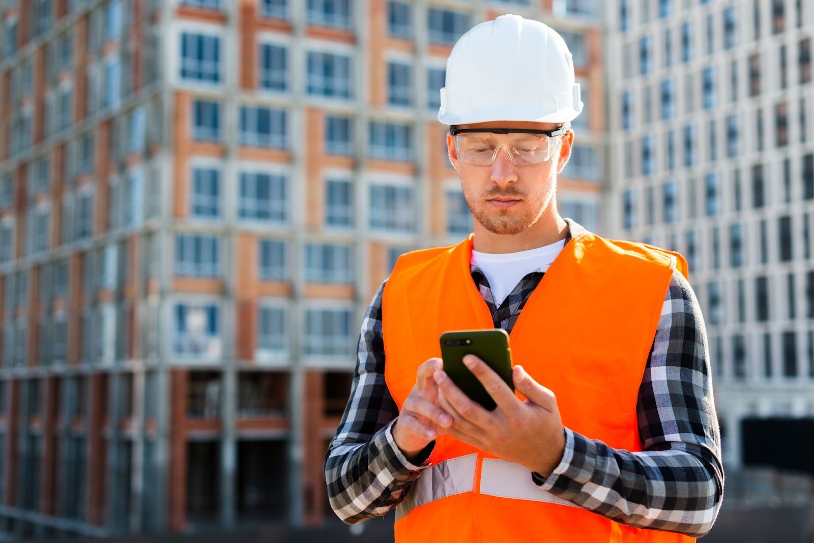 Construction worker using a smartphone on site