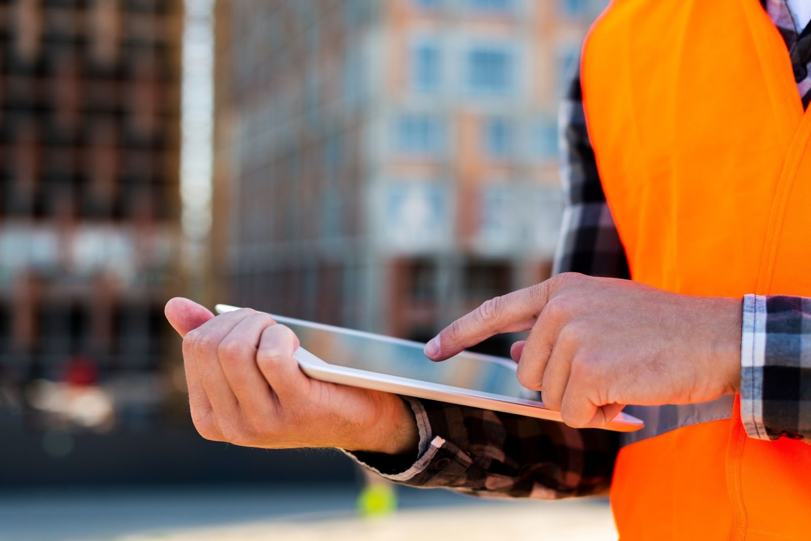 Hands using a tablet on a construction site