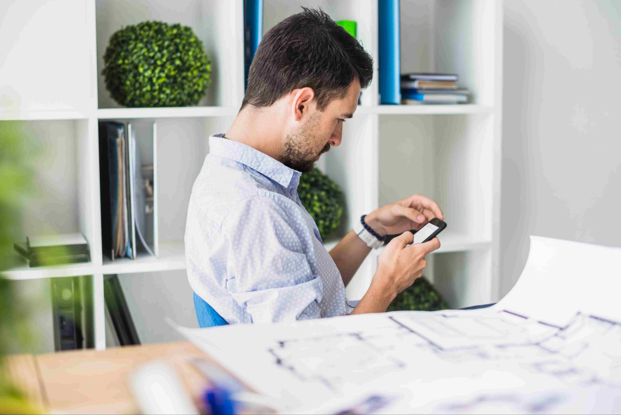 Man looking at phone in an office