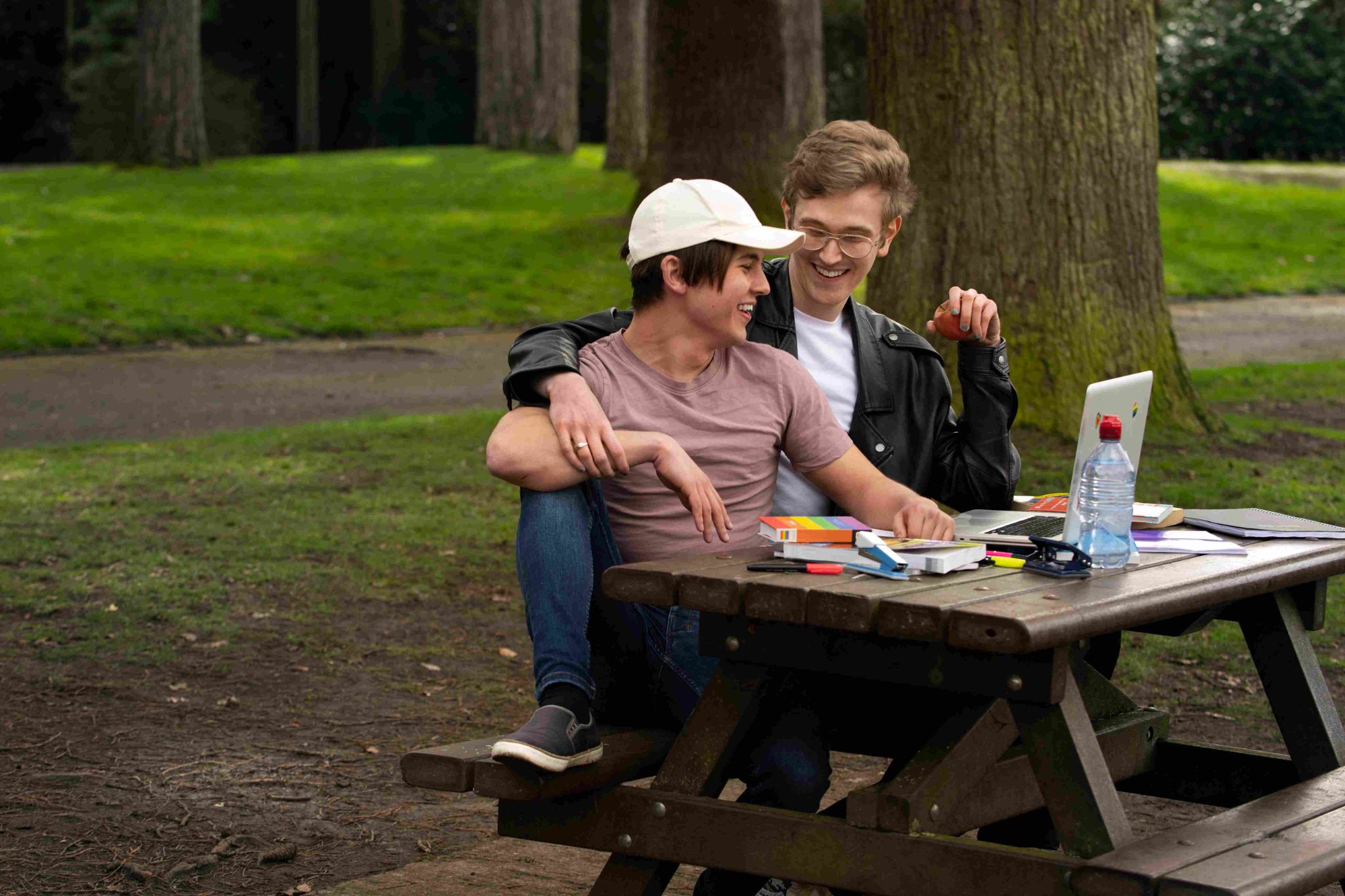 Two people looking at a laptop outdoors