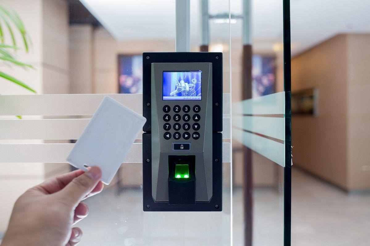 Person using a biometric attendance tracking card and fingerprint scanner