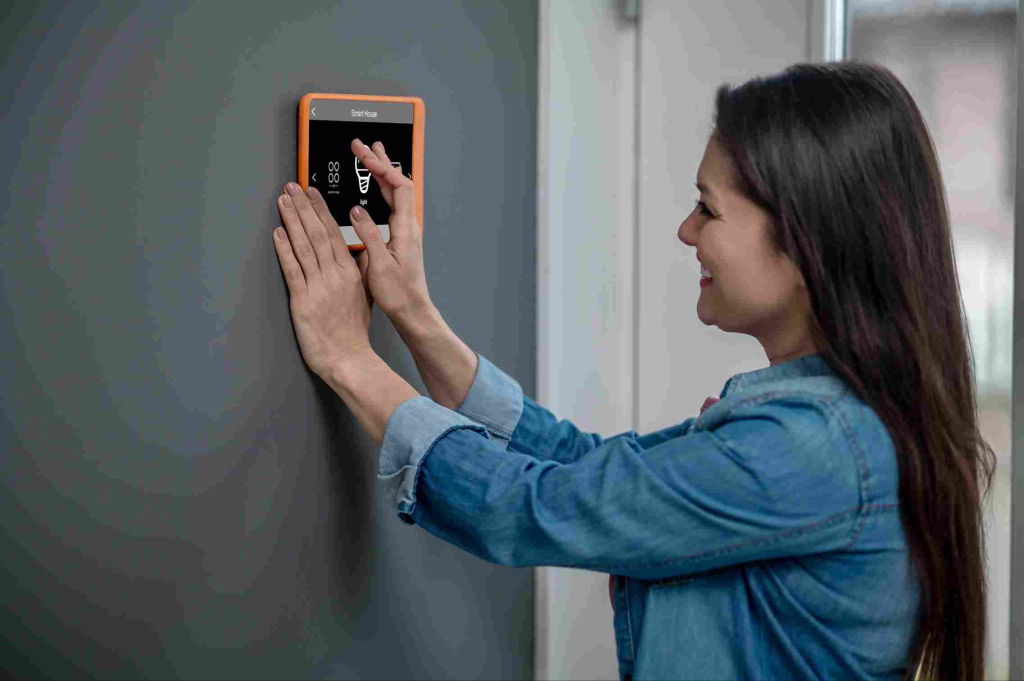 Woman clocking in using a wall-mounted biometric device
