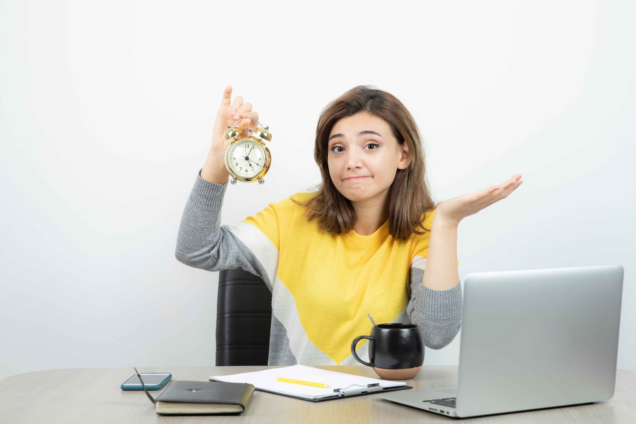 Woman holding an alarm clock looking confused