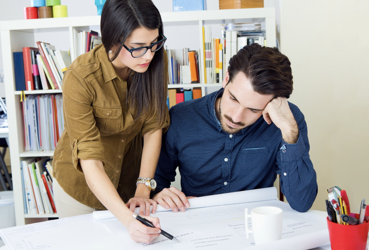Two people looking stressed over paperwork