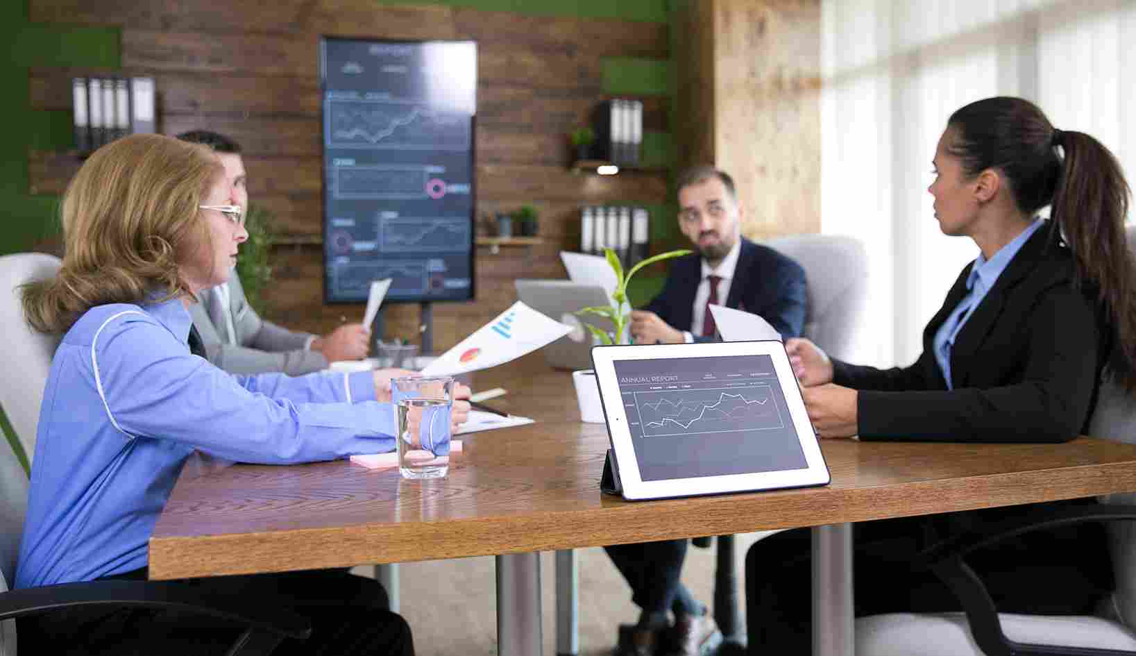 People in a meeting looking at screens