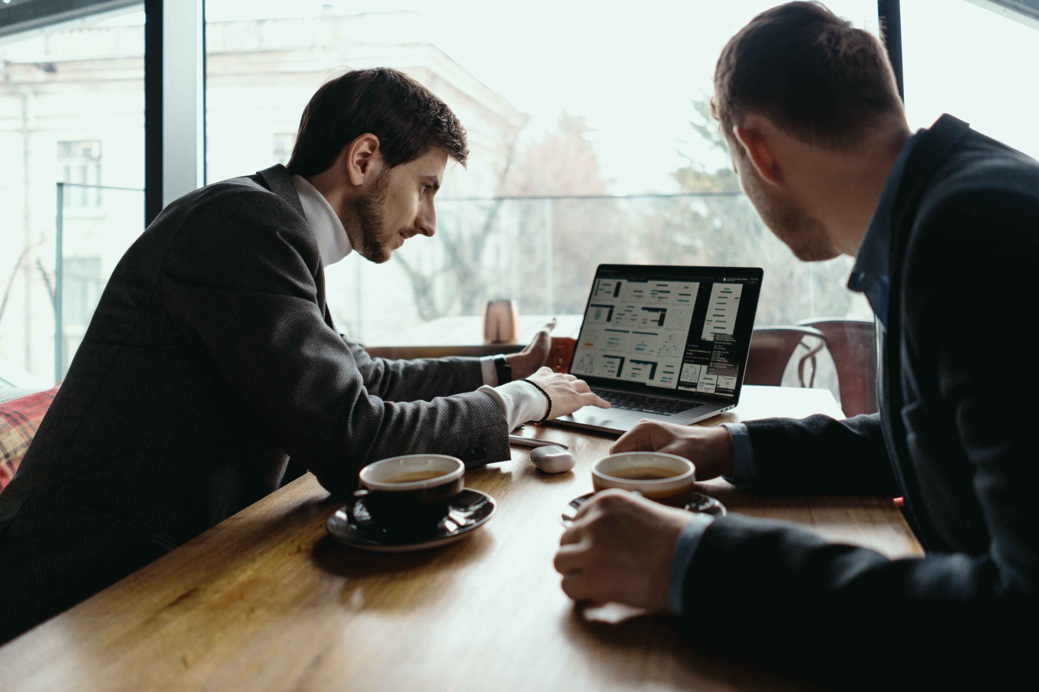 Two men reviewing time tracking software on a laptop