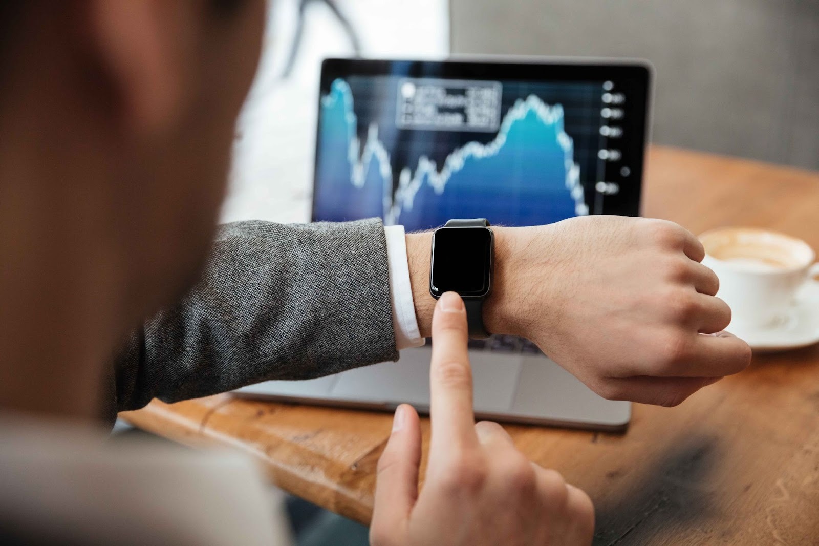 Person using smartwatch and graphs