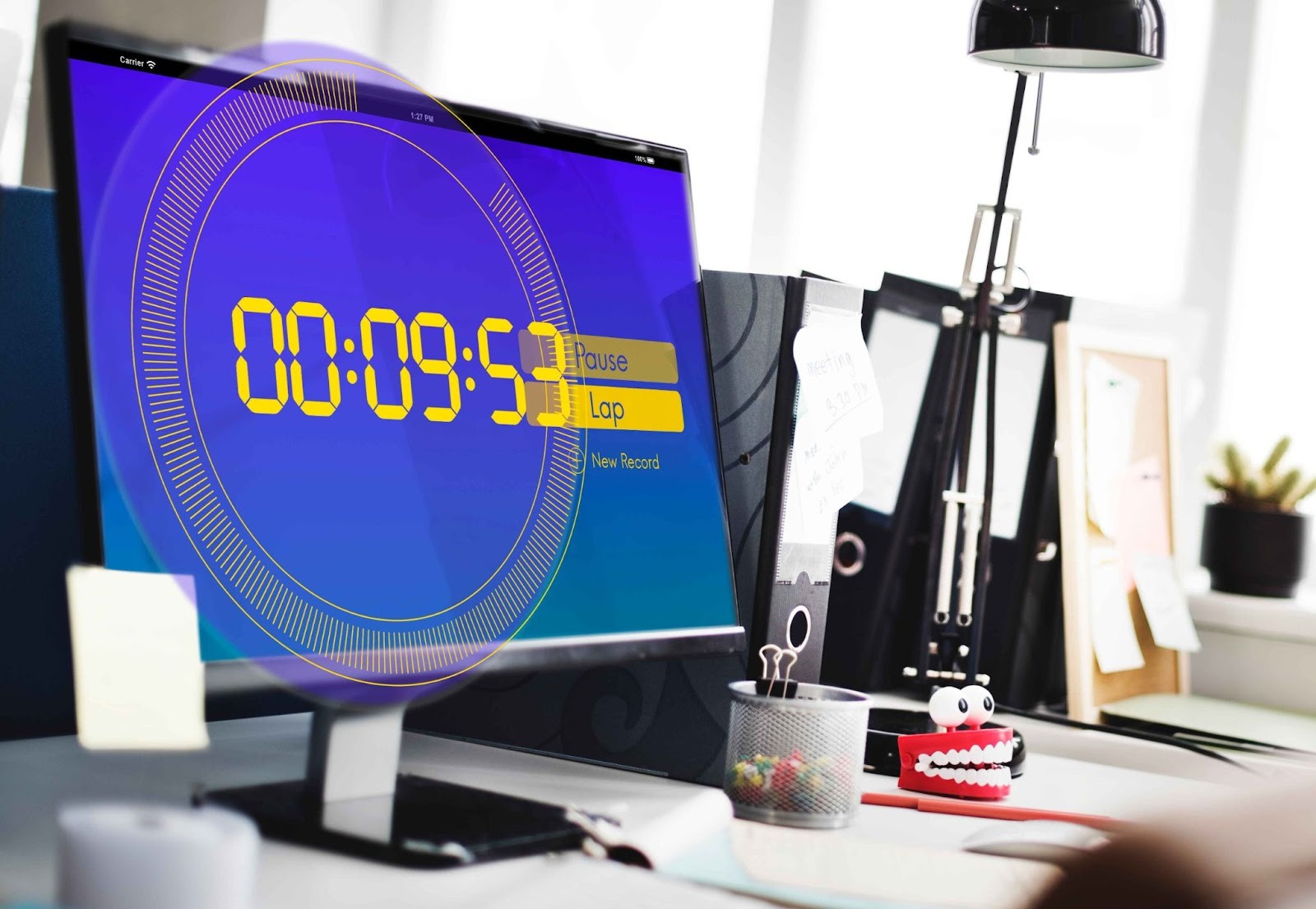 Desktop monitor displaying a digital clock on a modern desk