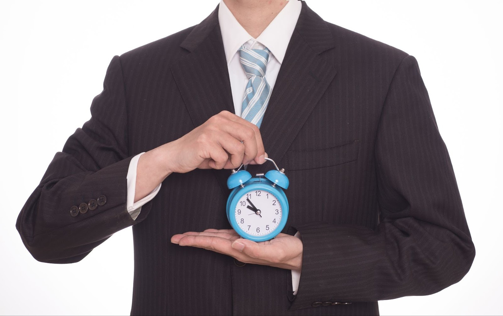 Person in suit holding a blue alarm clock