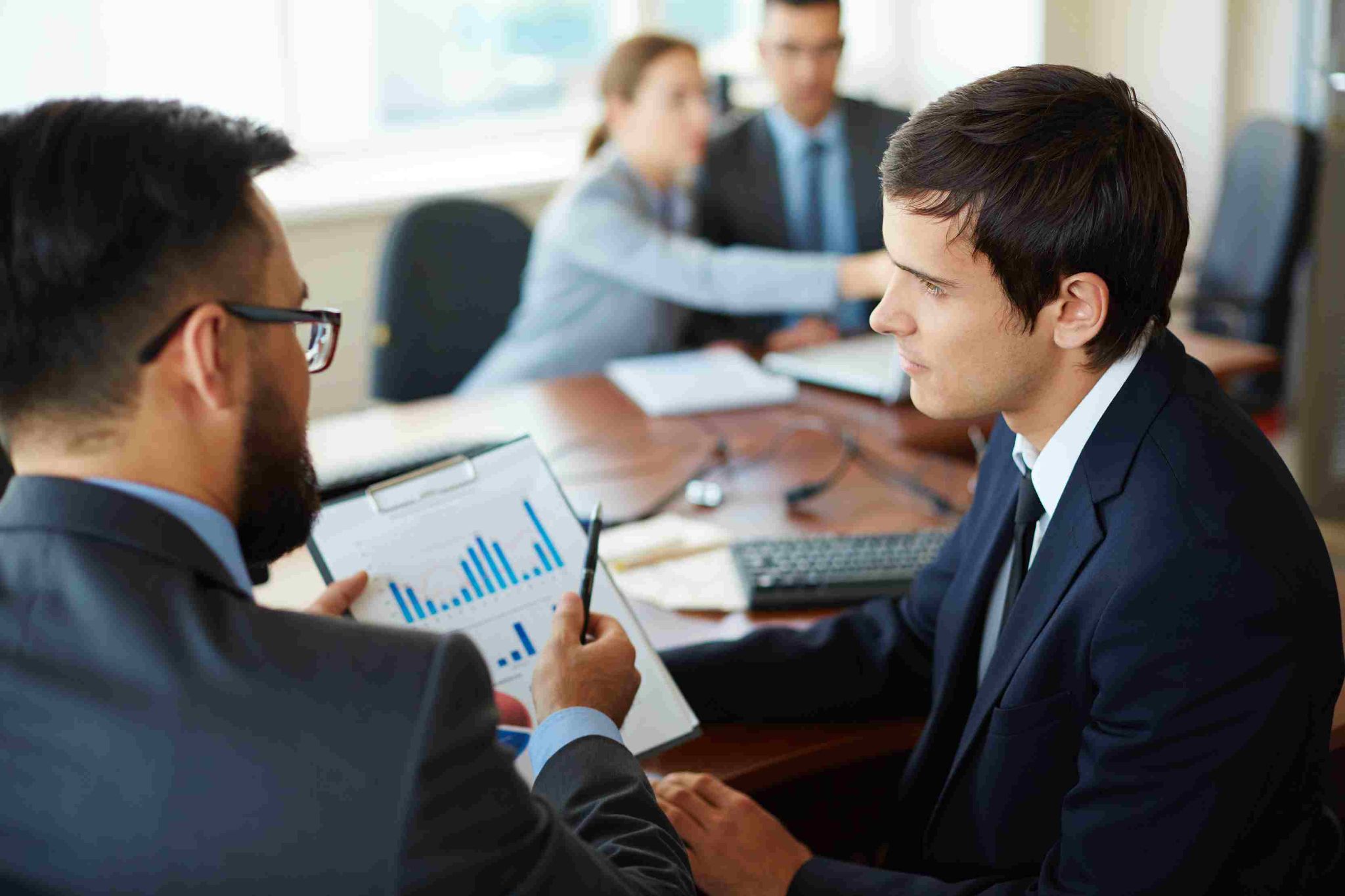 Professionals reviewing charts and data during a meeting