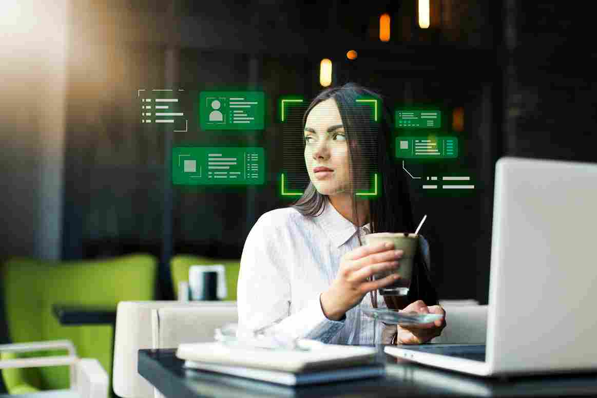 Woman at desk with facial recognition overlay