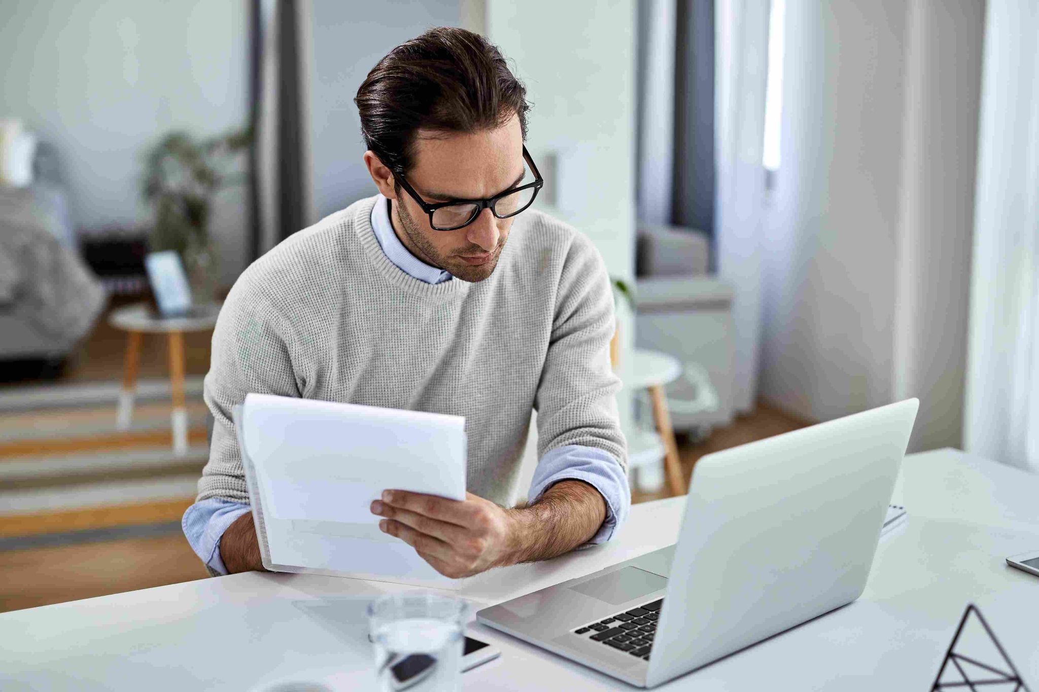 Man reviewing timesheets and laptop