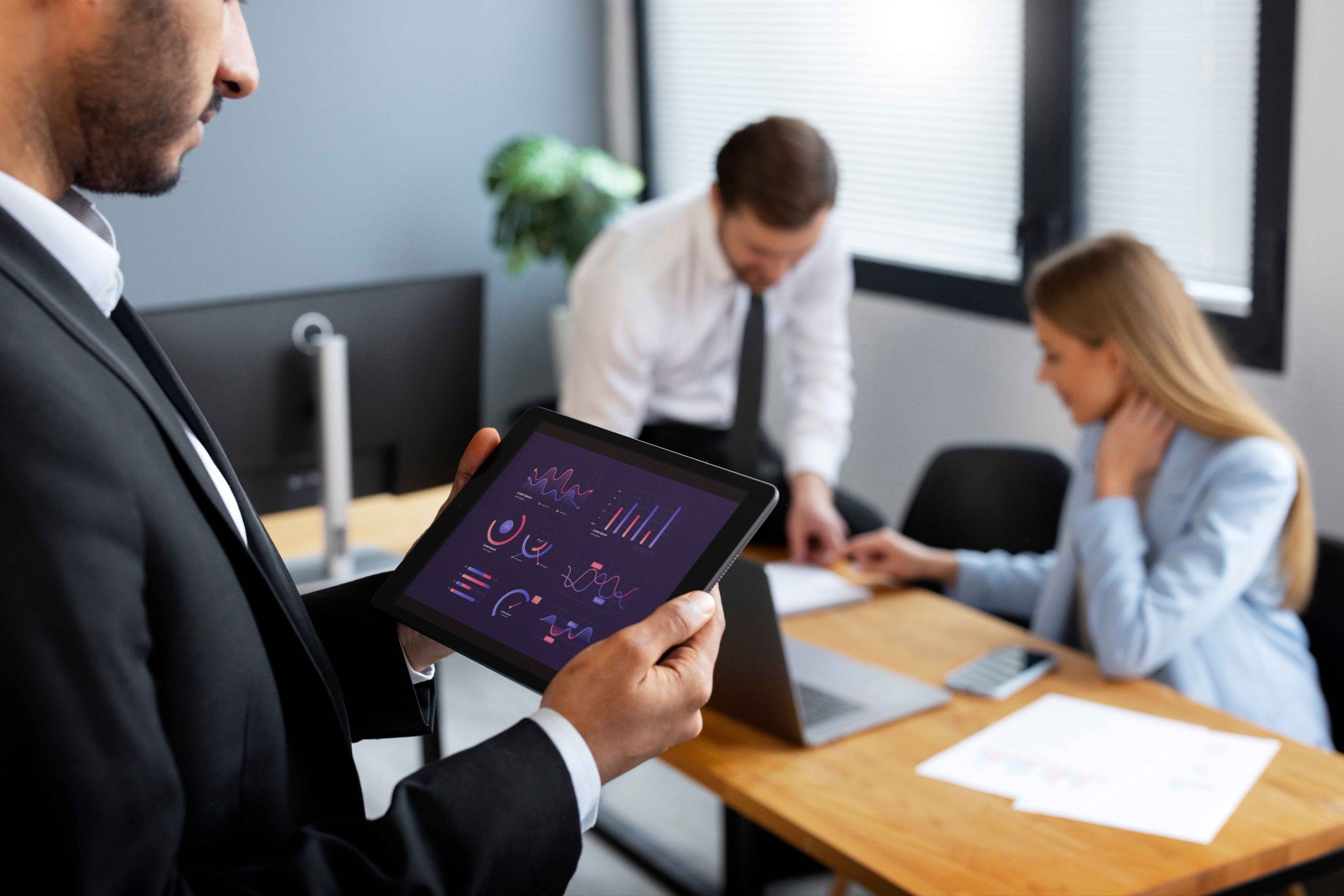 Business professionals analyzing data on a tablet