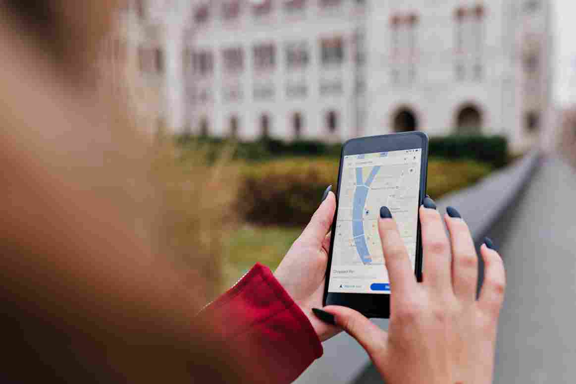 Person holding a smartphone showing a map with GPS location