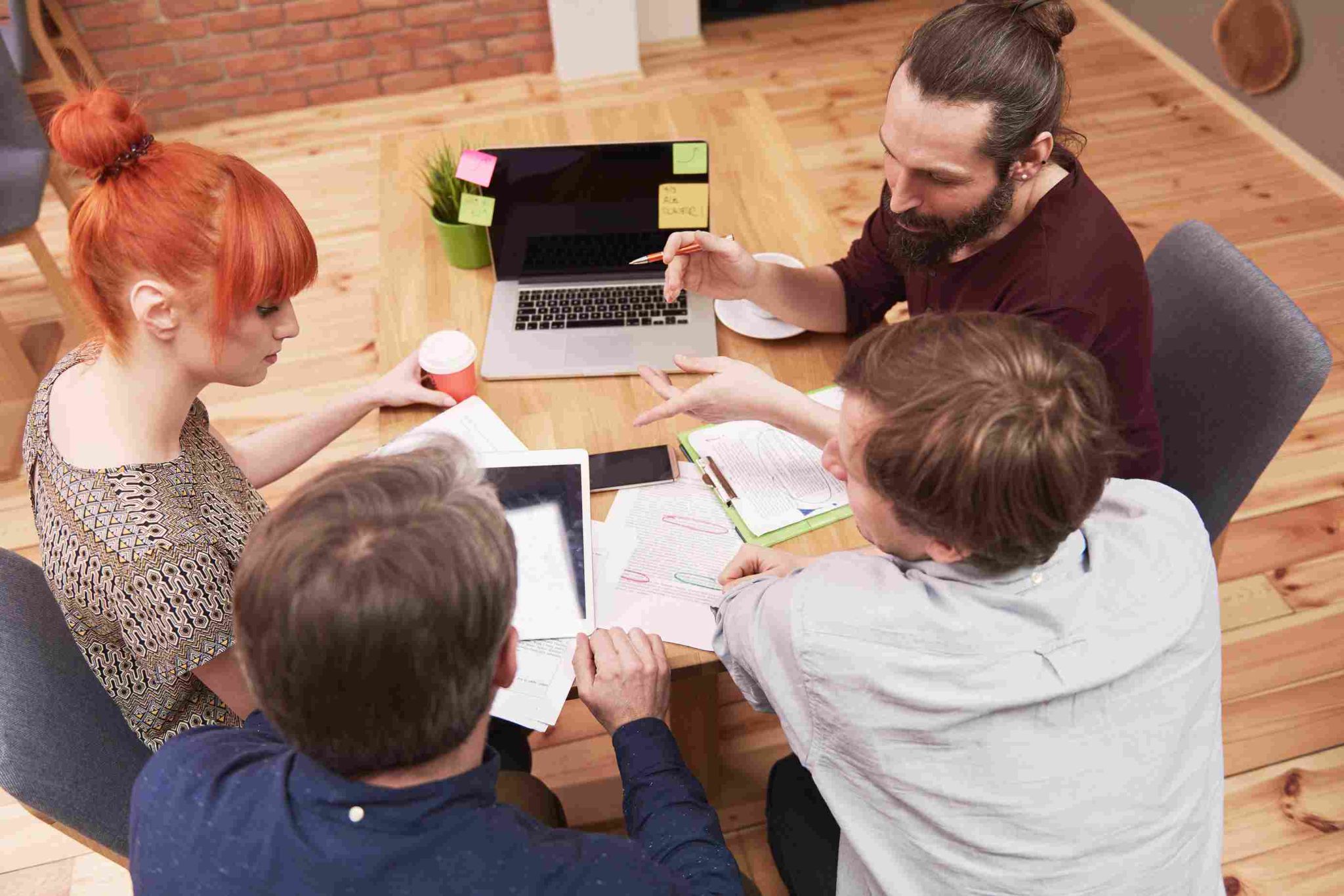 A diverse group of people sitting around a table having a meeting or discussion
