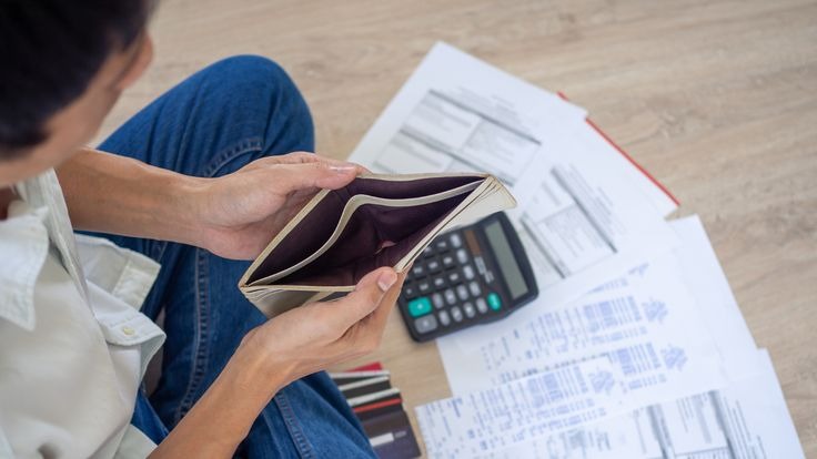 Person looking at bills and holding a wallet