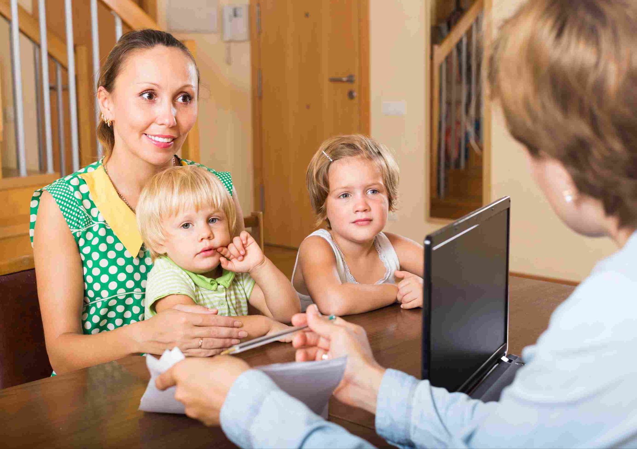 Daycare worker with children and a laptop