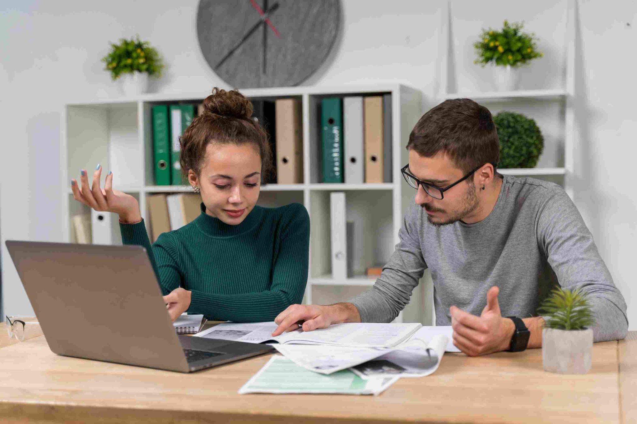 Man and woman discussing documents at a desk